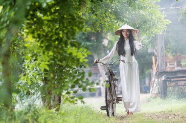 Kırsalda bir otobüste genç Vietnamlı bir kadın. Ao dai, Vietnam 'da kadınlar için ünlü bir geleneksel kostümdür..