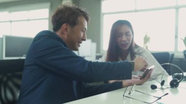 İş adamları iş yerinde eğleniyor ve sohbet ediyorlar. Hoş, yakışıklı, keyifli bir adam elinde cep telefonu, masada arkadaşıyla oturuyor..