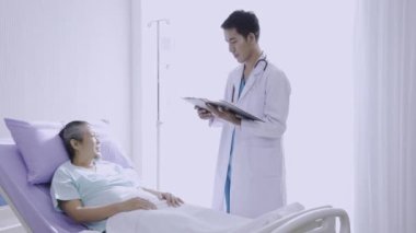 Doktor 'un bakımı altındaki hasta. Profesyonel üniformalı doktor hastanedeki hastayı muayene ediyor..