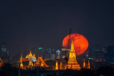 Big Moon with Golden Mount Bangkok and Thonburi Pagoda of Wat Arun in Bangkok, Thailand.