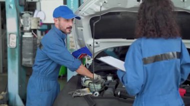 İki kişi. Kadın otomobilini tamir eden adam. Profesyonel hizmet. Profesyonel oto tamircisi ve tamirci.. 