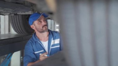 Araba tamircisi bir arabanın motorunu kontrol ediyor. Tamirci araba tamir ediyor. Otomobil hizmetleri ve Küçük işletme kavramları.