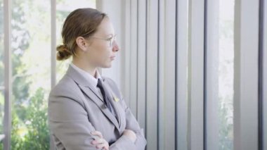 Kadın bir havayolu işçisi pencereden dışarı bakıyor. İş kadını arkası dönük duruyor ve ofis penceresinden içeri bakıyor.