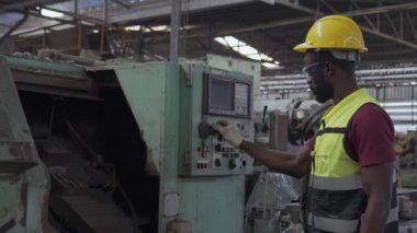 Personel veya teknisyenler eski makinenin çalışmasını kontrol ediyor. Genç teknisyen makine fabrikadaki otomatik CNC 'ye..