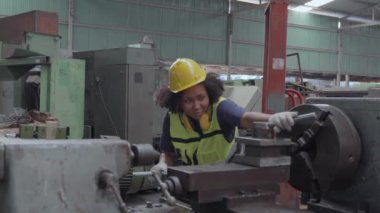 Genç teknisyen makine fabrikadaki otomatik CNC 'ye. Afrikalı Amerikan makine mühendisi endüstriyel torna makinesi kullanıyor..