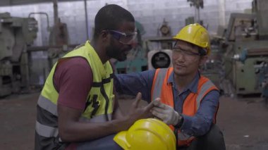 Endüstriyel fabrikada yaralı meslektaşlarına Asyalı işçiler bakıyor