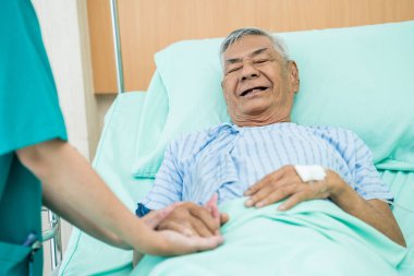 Hemşirenin eli hastanede buruşuk bir eli dokunup tutuyor..