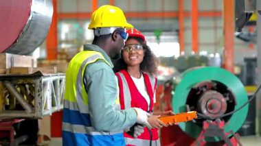 Fabrikadaki endüstriyel makinelerde çalışan bir mühendis. Bir erkek ve kadın mühendis çalışanları kontrol ediyor..