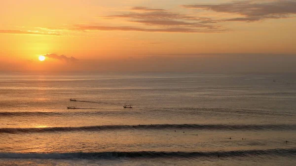 夕暮れ時にサーファーや漁師が海で出会うウルワツビーチでの素晴らしい夕日 ウルワツ インドネシア — ストック写真