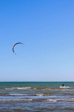 Ebro Nehri Delta Milli Parkı 'nda dalgaların üzerinde uçan uçurtmacı, İspanyol sahilinin en muhteşem noktalarından biridir (uçurtmadan ve tahtadan kaldırılan tüm marka isimleri ve logolar).