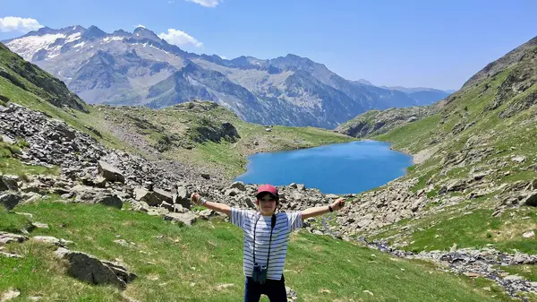 stock image Joyful little kid portrait with Gorgutes lake and snowy Pyrenees mountains on background on a sunny summer day, Benasque, Spain.