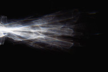 Siyah zemin üzerindeki kristal soyut tasarımdan yansıyan ışık patlaması. Yakın plan..