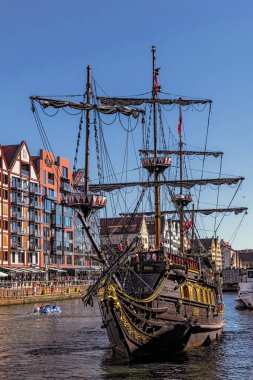 Gdansk, Poland - July  03, 2022: Riverbank of the Motlawa river in Gdansk and vintage recreational boat. Summer vacations on the Baltic Sea
