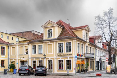 Potsdam, Germany - January 02, 2023: Ancient colourful houses in the historic district in Potsdam. Old buildings and cars on the street. Life in a European town