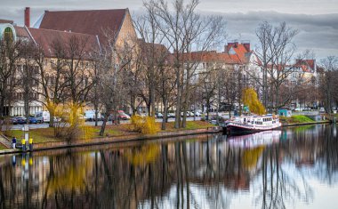 Berlin, Germany - January 01, 2023: recreational boat moored at the embankment of the Spree river in Berlin. Winter in Germany