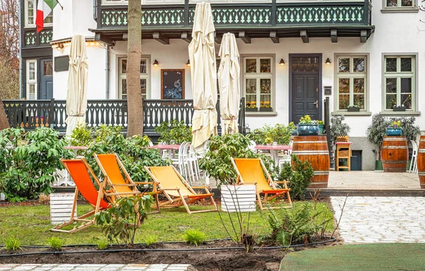 Orange lounge chairs in a green summer garden