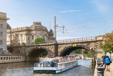 Berlin, Almanya - 25 Eylül 2022: Berlin 'deki tarihi bölgenin manzarası. Evanjelik Yüksek Kilise ve Kolej Kilisesi, Müze Adası ve Spree Nehri 'nde bir eğlence teknesi.