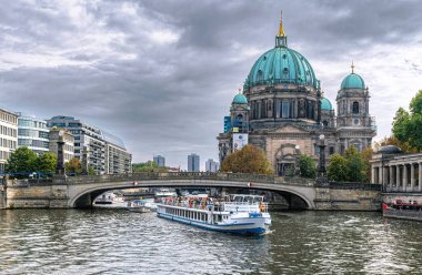 Berlin, Almanya - 25 Eylül 2022: Berlin 'deki tarihi bölgenin manzarası. Evanjelik Yüksek Kilise ve Kolej Kilisesi, Müze Adası ve Spree Nehri 'nde bir eğlence teknesi.