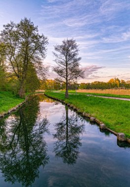 Rural landscape, river among green meadows