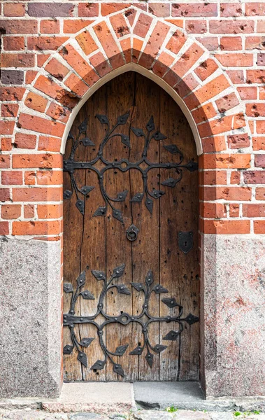 stock image Carved wooden old door and a brick wall