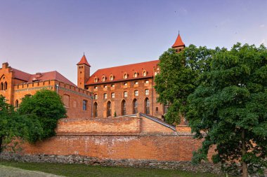 Gniew, Polonya - 8 Haziran 2023: güzel ortaçağ teutonik şatosu Gniew ve günbatımı gökyüzü. Alman Töton şövalyelerinin ve Prusya 'nın ünlü tarihi simgesi. Polonya tarihi mirası