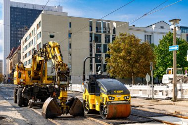 Berlin, Almanya - 25 Eylül 2022: Berlin şehir merkezindeki caddede sarı kazıcı ve yol yapım ekipmanları. Almanya 'da yol yapımı ve yenilenmesi
