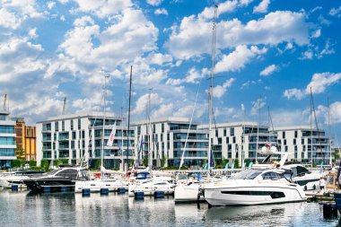 Gdynia, Polonya - 7 Haziran 2022: Gdynia 'daki modern şehir manzarası. Gökdelenler ve mavi gökyüzüne karşı pahalı yatları olan bir marina, Baltık Denizi 'nin seti ve limanı.