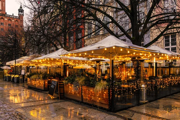 Beautiful shiny sidewalk cafe in the winter city