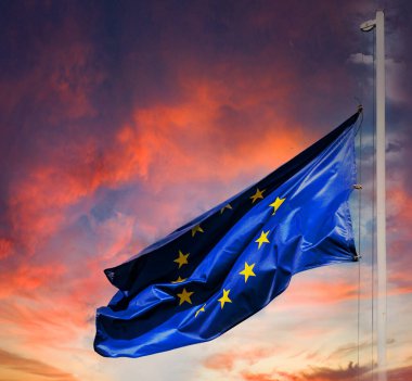 Avrupa Birliği bayrağı ve günbatımı gökyüzü. Sarı yıldızlı mavi bayrak
