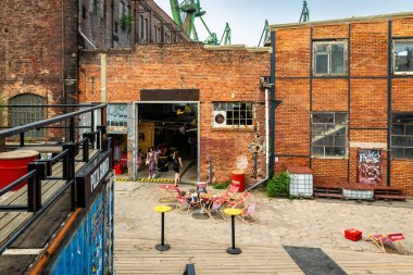Gdansk, Polonya - 25 Haziran 2024: Gdansk 'taki tarihi tersanenin ünlü turizm ve eğlence alanı. Yıkılan sanayi binaları, vinçler ve gıda alanları