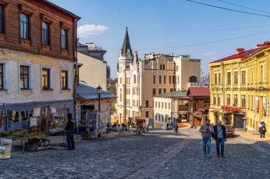 Kyiv, Ukrayna - 23 Mart 2025: Kyiv, Andriivskyj 'in tarihi Podil ilçesindeki güzel eski evler. Güneşli bir bahar günü ve insanlar sokakta yürüyor.