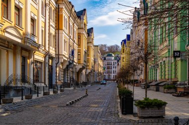 Kyiv, Ukrayna - 23 Mart 2025: Kyiv, Andriivskyj 'in tarihi Podil ilçesindeki güzel eski evler. Güneşli bir bahar günü ve insanlar sokakta yürüyor.