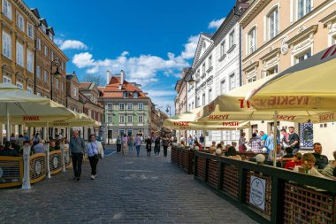 Varşova, Polonya - 20 Nisan 2025 bahar tatili, Varşova 'da Paskalya kutlaması. Varşova 'daki tarihi meydanda, Royal Castle' da ve Barbican 'da yürüyen insanlar. Kaldırımdaki kafeyi aç