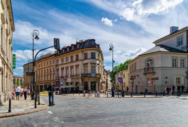 Varşova, Polonya - 20 Nisan 2025: Polonya 'nın başkenti Varşova' da güzel şehir manzarası. Saat kulesi ve caddelerdeki ulaşım trafiği olan antik güzel bir bina.
