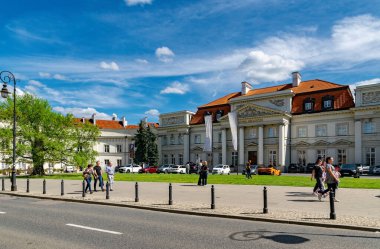 Varşova, Polonya - 20 Nisan 2025: Polonya 'nın başkenti Varşova' da güzel şehir manzarası. Saat kulesi ve caddelerdeki ulaşım trafiği olan antik güzel bir bina.