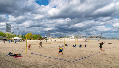 Gdynia, Polonya - 4 Mayıs 2025: Gdynia şehri ve Baltık Denizi kıyısındaki kumlu plaj. İnsanlar sahilde voleybol oynayıp eğleniyorlar.