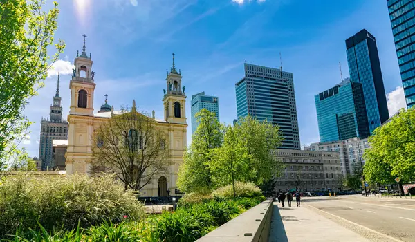 Varşova, Polonya - 20 Nisan 2025: Modern gökdelenlerin yüksek demir ve cam binaları ve Varşova şehir merkezindeki caddede trafik. Ofis inşaatı ve şirket işleri 