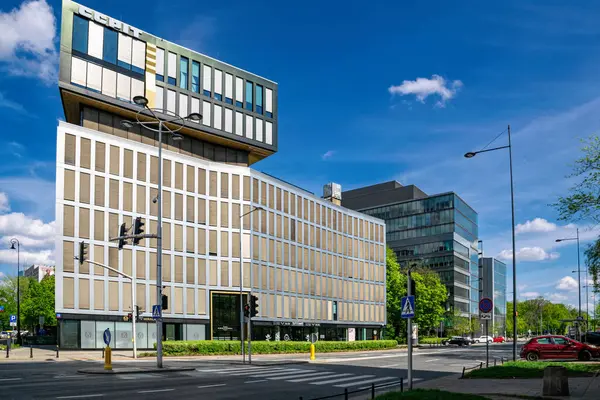 Varşova, Polonya - 20 Nisan 2025: Modern gökdelenlerin yüksek demir ve cam binaları ve Varşova şehir merkezindeki caddede trafik. Ofis inşaatı ve şirket işleri 