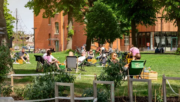 Gdansk, Polonya - 01 Haziran 2025: Yazlık şehir parkında piknik. İnsanlar yeşil çimenlikteki güneş gözlüklerinde dinleniyorlar. Sokak yemekleri ve içecekler, yaz restoranı.