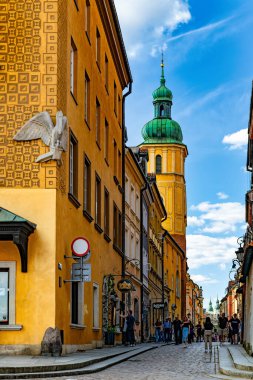 Varşova, Polonya - 20 Nisan 2025: Eski Varşova 'da tarihi evler ve dar tarihi caddeler. Ortaçağ Avrupa mimarisi ve yürüyen turistler