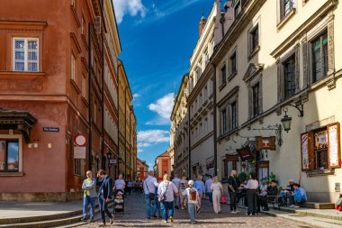 Varşova, Polonya - 20 Nisan 2025: Eski Varşova 'da tarihi evler ve dar tarihi caddeler. Ortaçağ Avrupa mimarisi ve yürüyen turistler