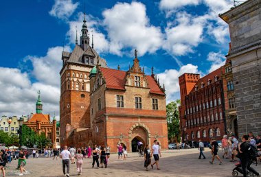 Gdansk, Polonya - 25 Mayıs 2025: Gdansk Eski Kasabası 'ndaki güzel ortaçağ gotik mimarisi ve renkli cepheler. İnsanlar tarihi caddede yürüyor.