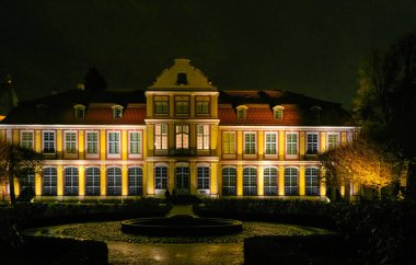 Beautiful building of the ancient Oliwa cathedral and public park at night