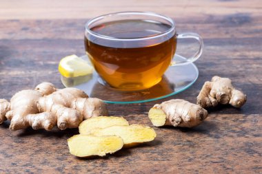 Tahta masada dilimlenmiş limonla zencefil köküne odaklan.