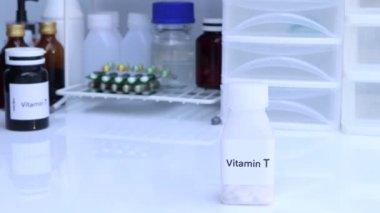 Şişedeki T vitamini hapları, sağlık için gıda takviyesi ya da hastalıkların tedavisinde kullanılır.