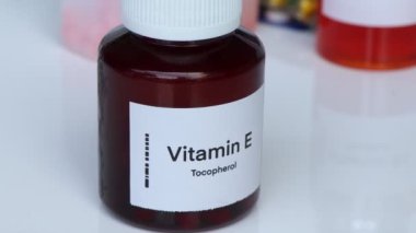 Şişedeki E vitamini hapları, sağlık için gıda desteği ya da hastalıkların tedavisinde kullanılır.