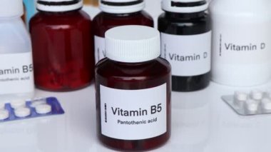Şişedeki B5 vitamini hapları, sağlık için gıda desteği ya da hastalıkların tedavisinde kullanılır.
