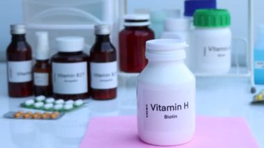 Şişedeki H vitamini hapları, sağlık için gıda takviyesi ya da hastalıkların tedavisinde kullanılır.