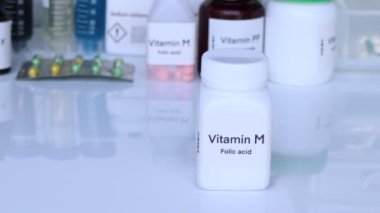 Şişedeki M vitamini hapları, sağlık için gıda takviyesi ya da hastalıkların tedavisinde kullanılır.