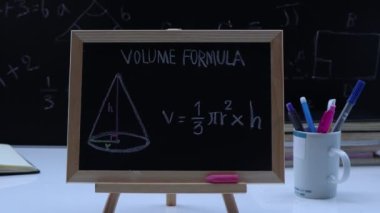 Blackboard with hand written geometry volume formulas and geometric shapes and figures